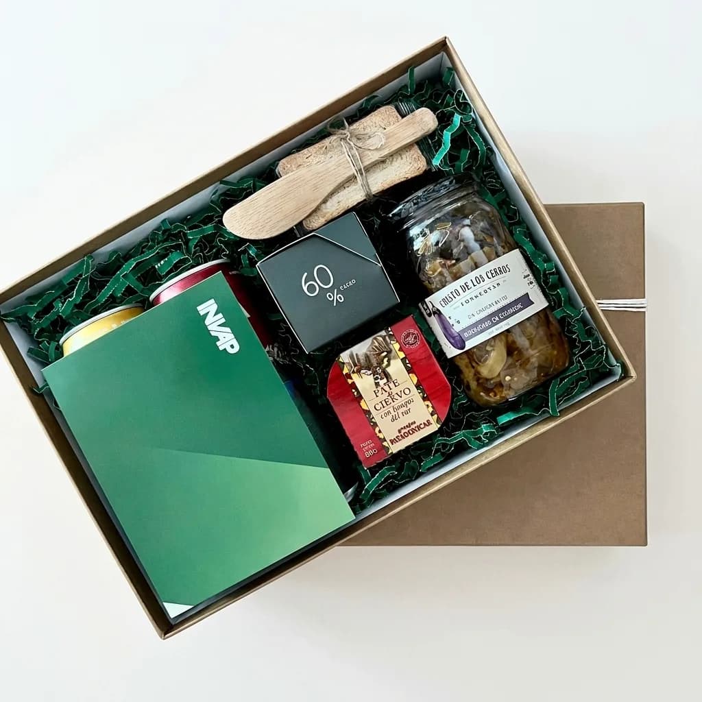Caja de aniversario de INVAP con conservas regionales, chocolate, tabla de madera y carpeta institucional