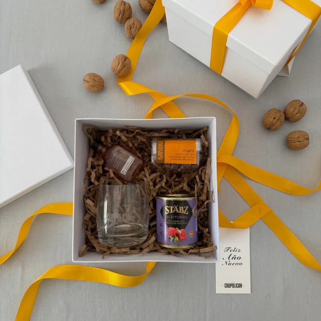 Box de fin de año de Caupolicán: whisky, vaso grabado, aceitunas y maní con chocolate en caja blanca